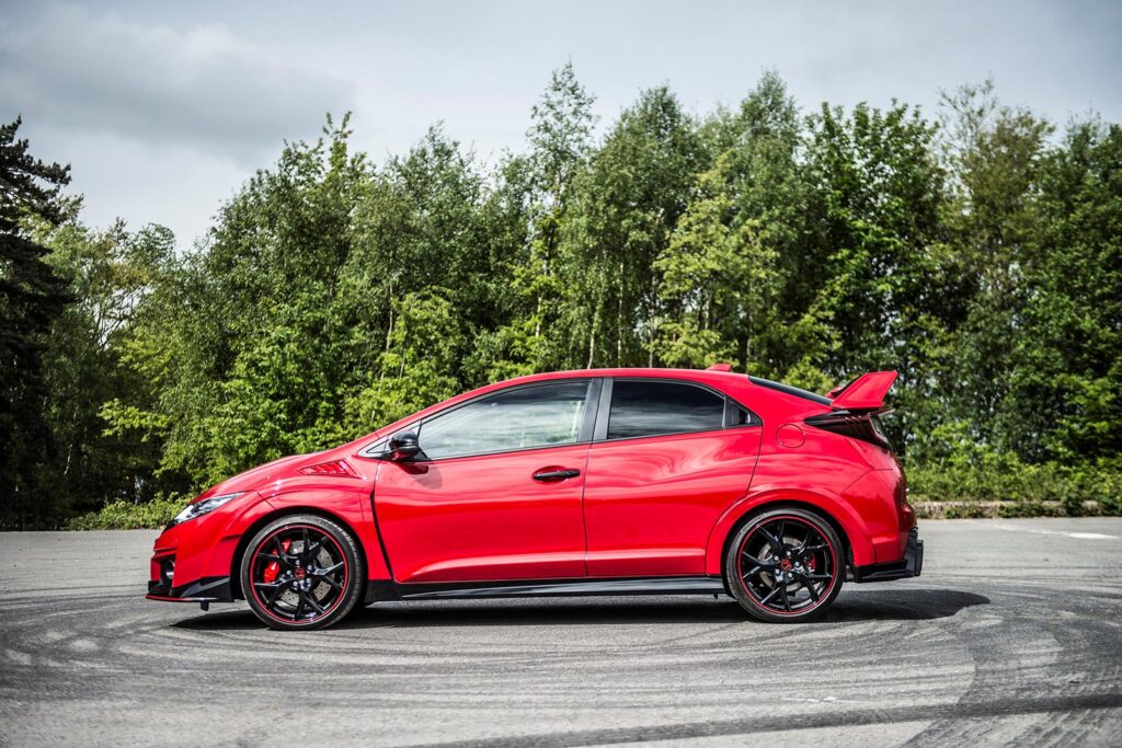 side profile of red honda on road