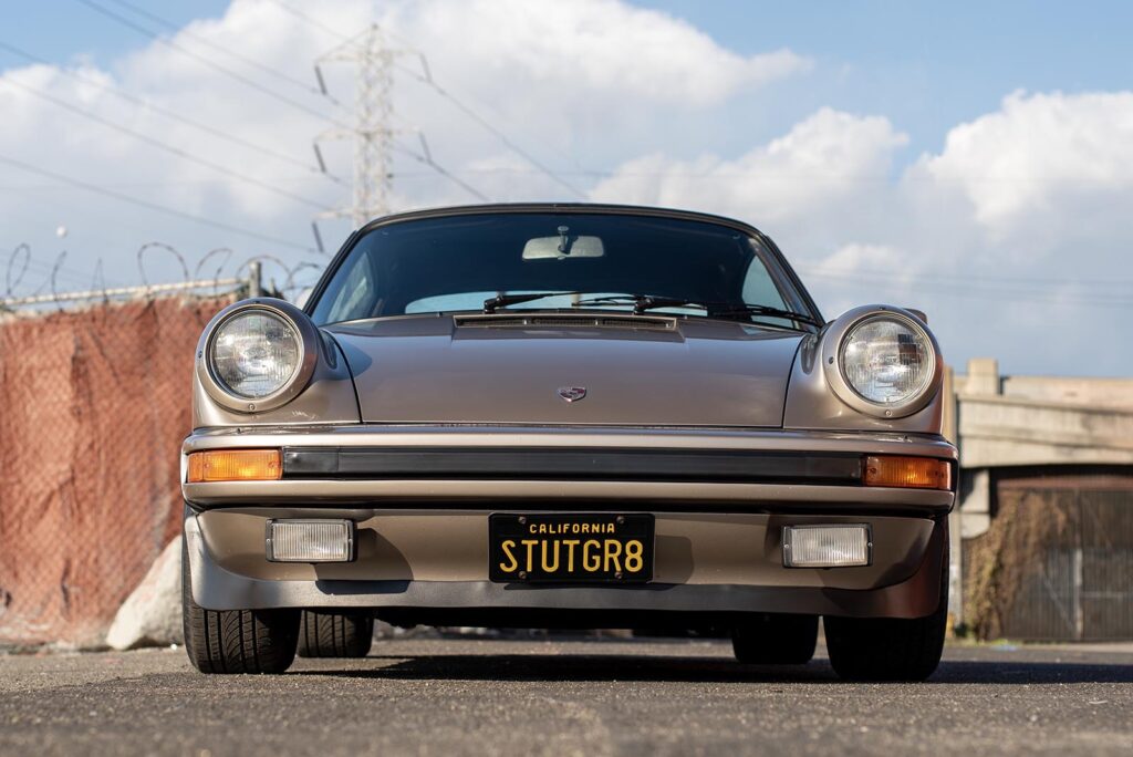 Bronze Porsche on road clouds in sky