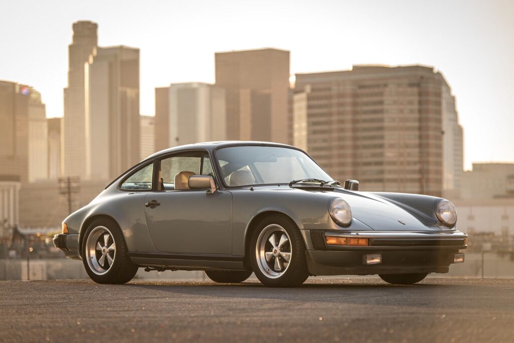 Bronze 911 SC on road with city skyline