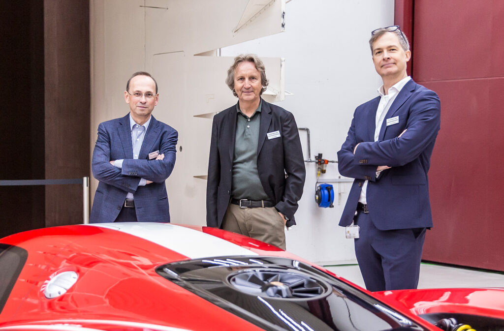 three men standing next to a car