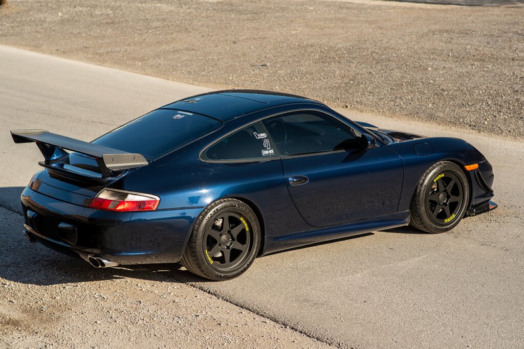 blue Porsche 911 996 on dirt road