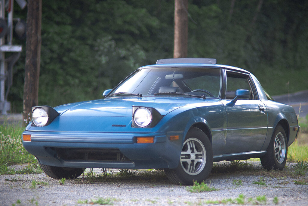 blue RX7 on gravel road