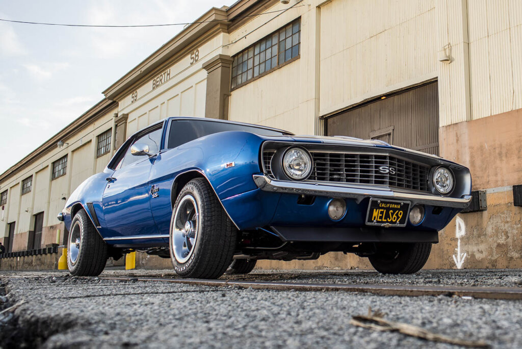 1969 blue camaro ss next to a warehouse