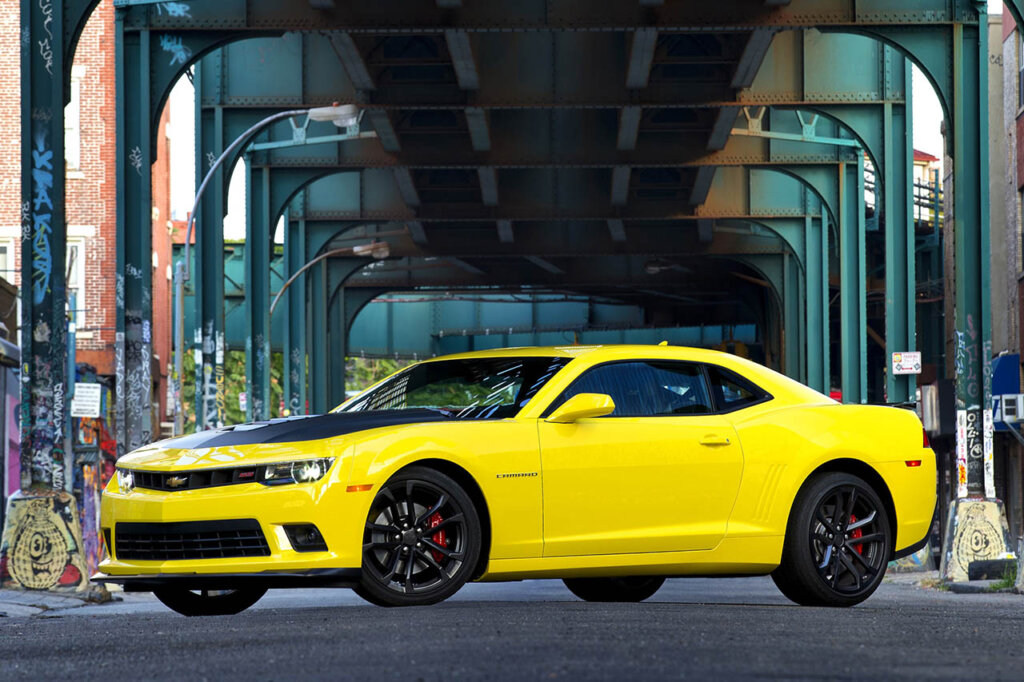 yellow 5th gen camaro under a bridge