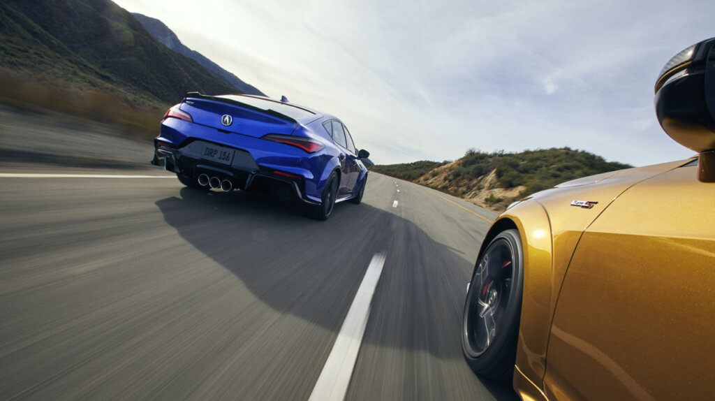 rear view of a blue and yellow Acura Integra Type-S racing down a highway