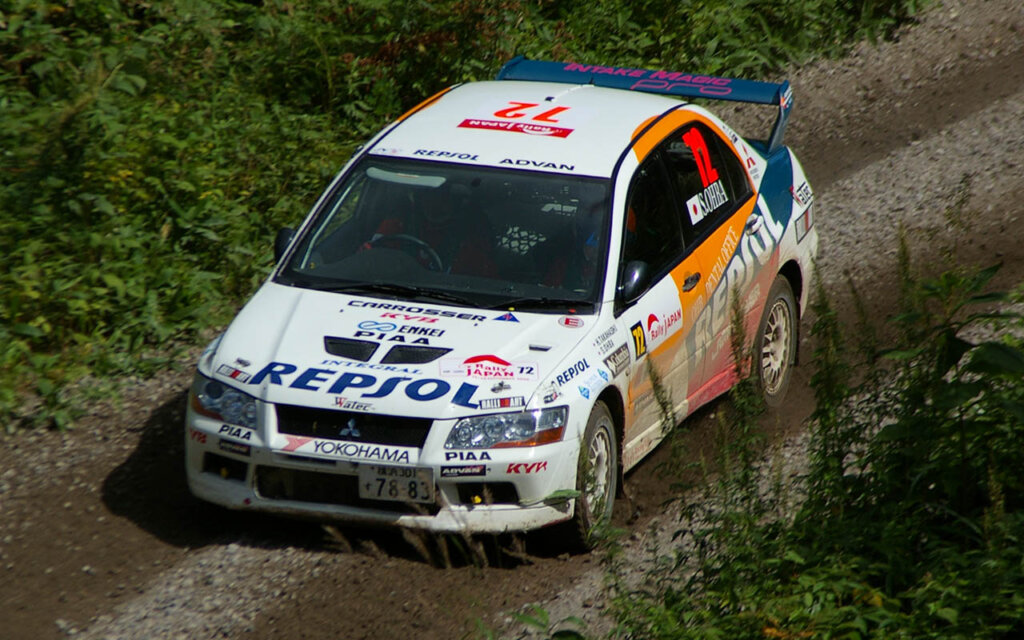 Mitsubishi Lancer EVO VII rally car driving through grass