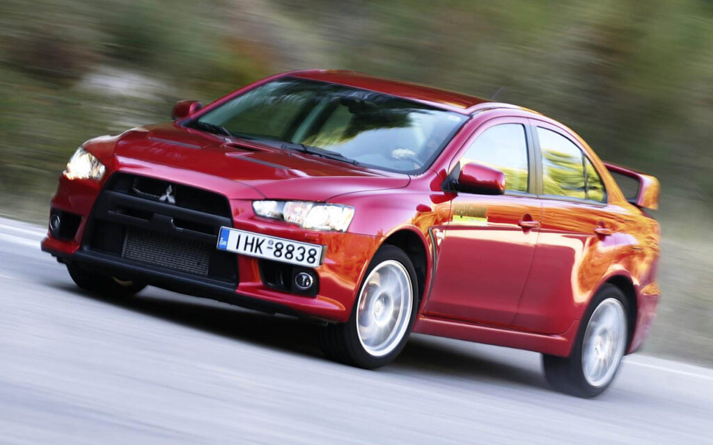 red mitsubishi lancer evo X speeding on highway