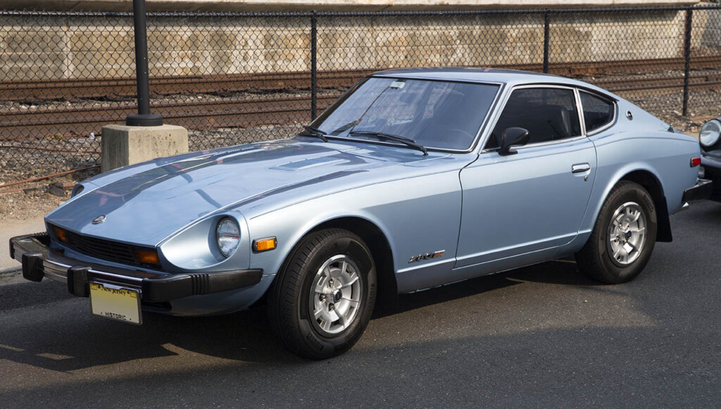 sky blue 280z next to train tracks