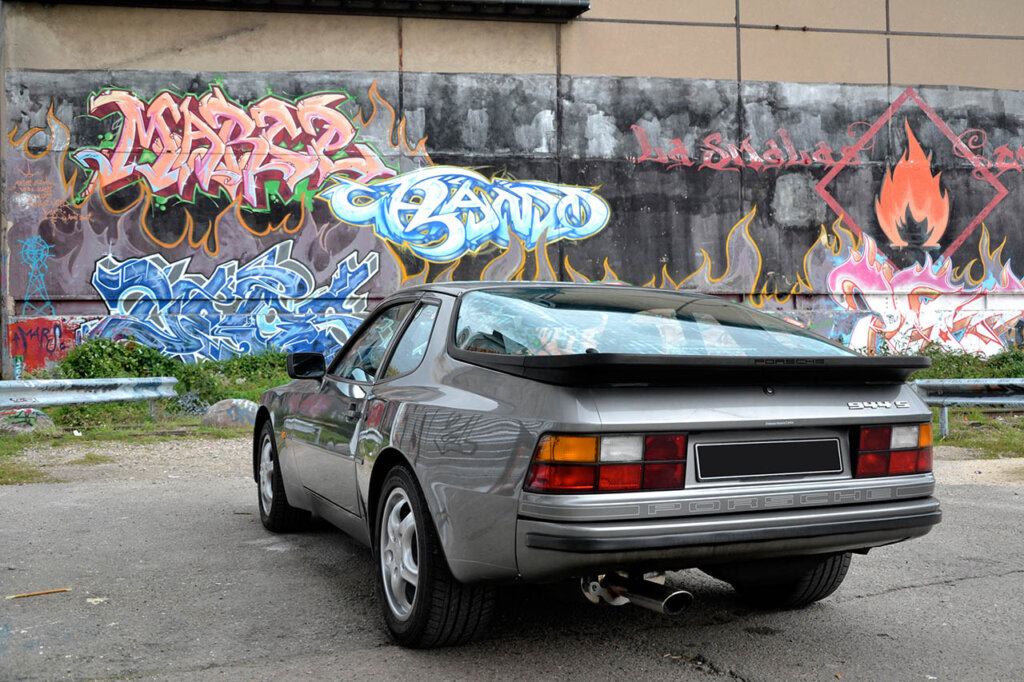 silver porsche 944 s next to graffiti wall