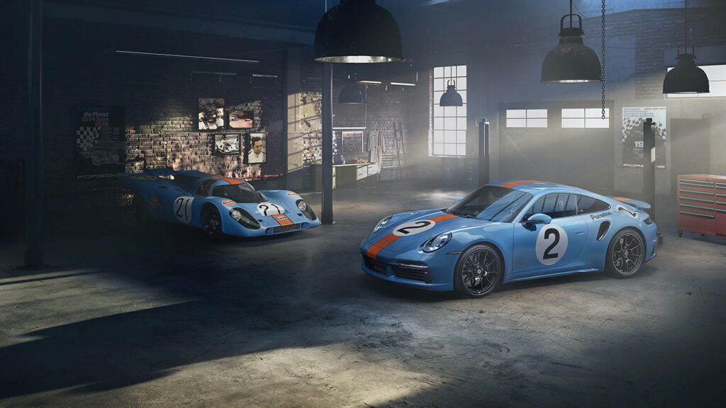 porsche 917 kh and porsche 911 turbo s with blue/orange livery in a garage