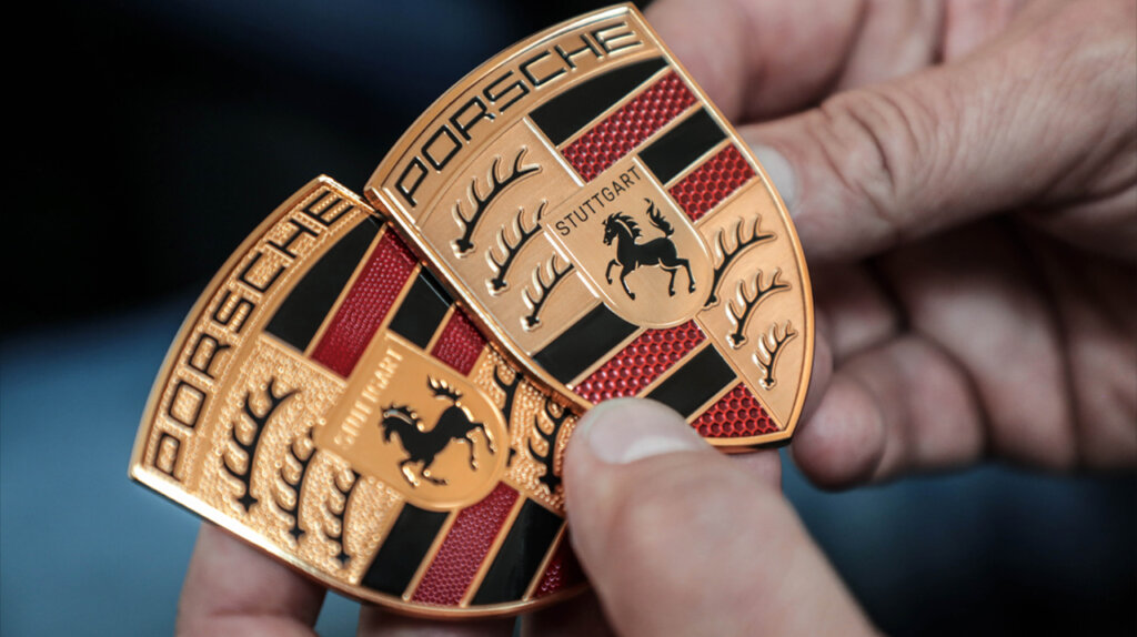 New vs old Porsche crests in hand