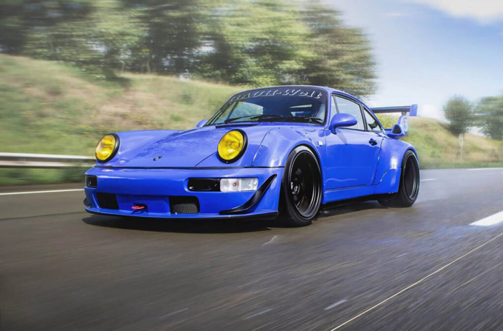 maritime blue porsche 964 driving on a road