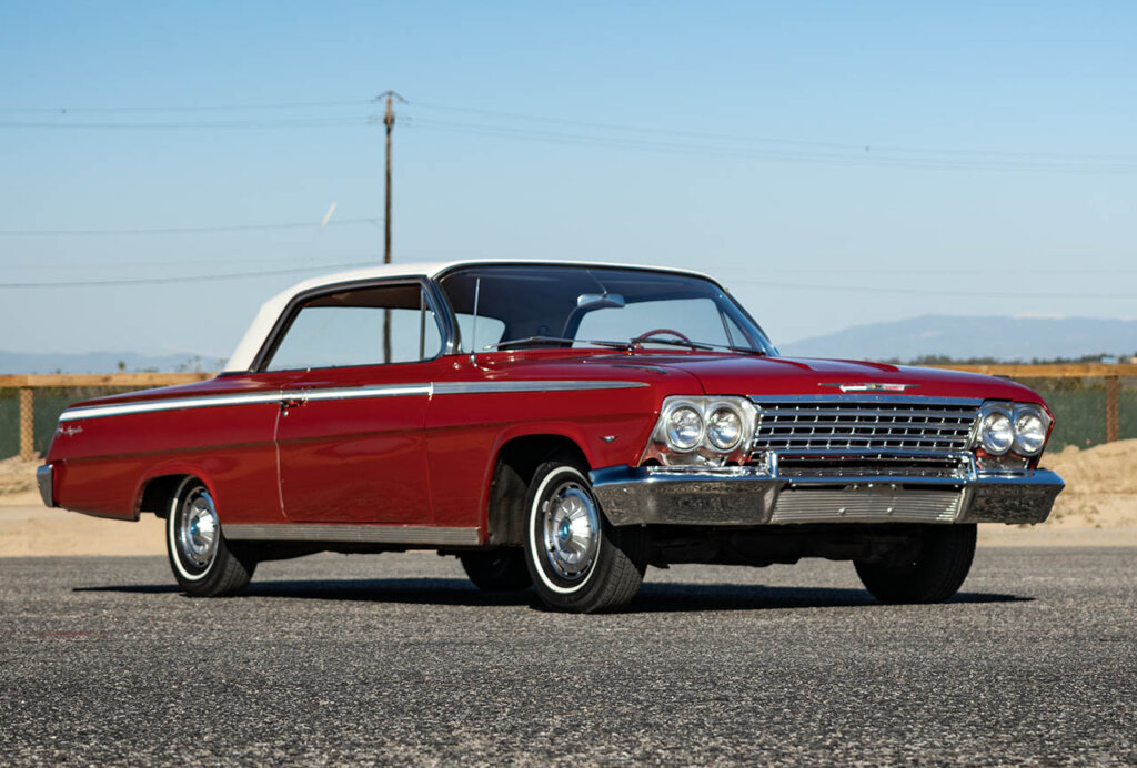 red 1962 impala at a beach