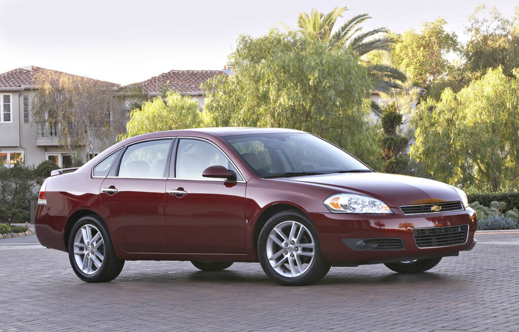 red 2010 Chevrolet Impala LTZ in front of a mansion