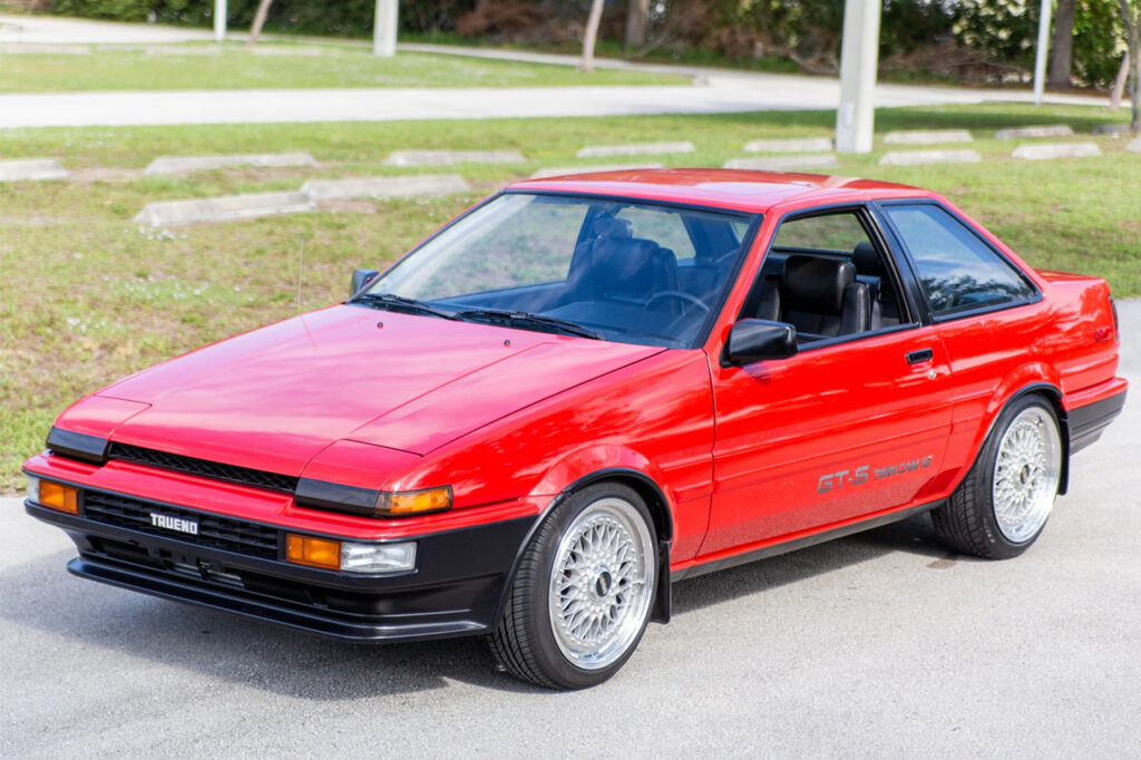 red corolla parked near grass