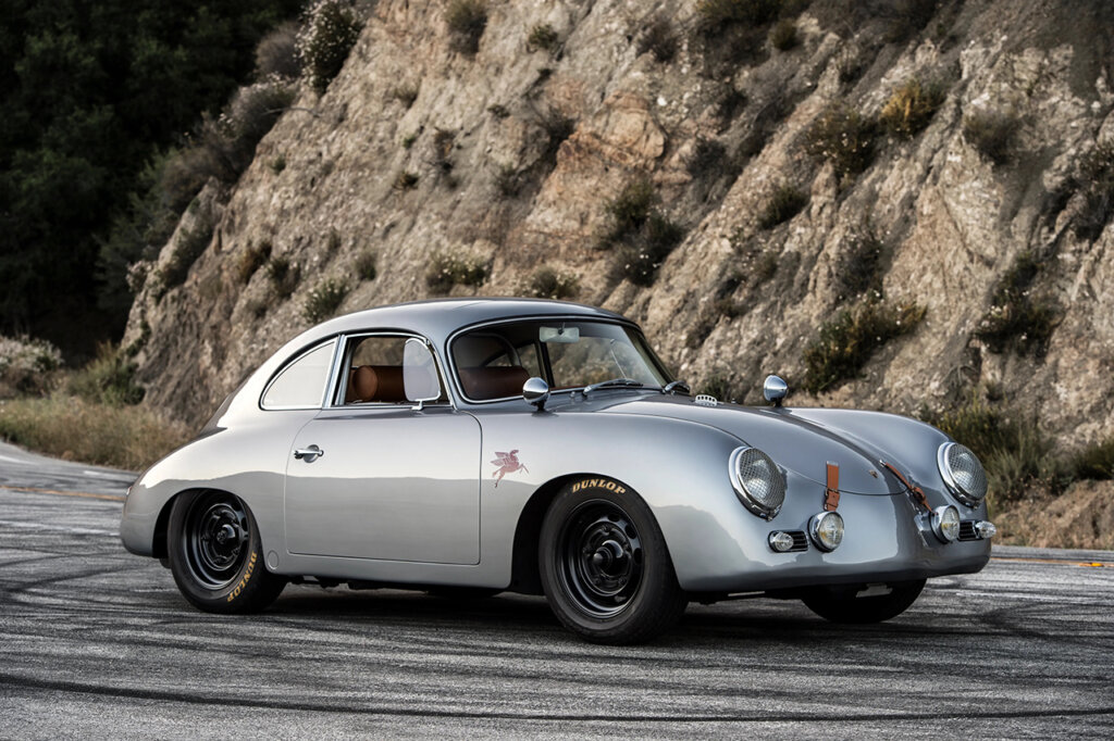 silver 356 Porsche next to mountain on tire streaked road