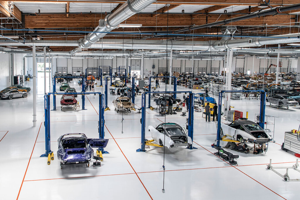 big garage with vehicles on car lifts white ground
