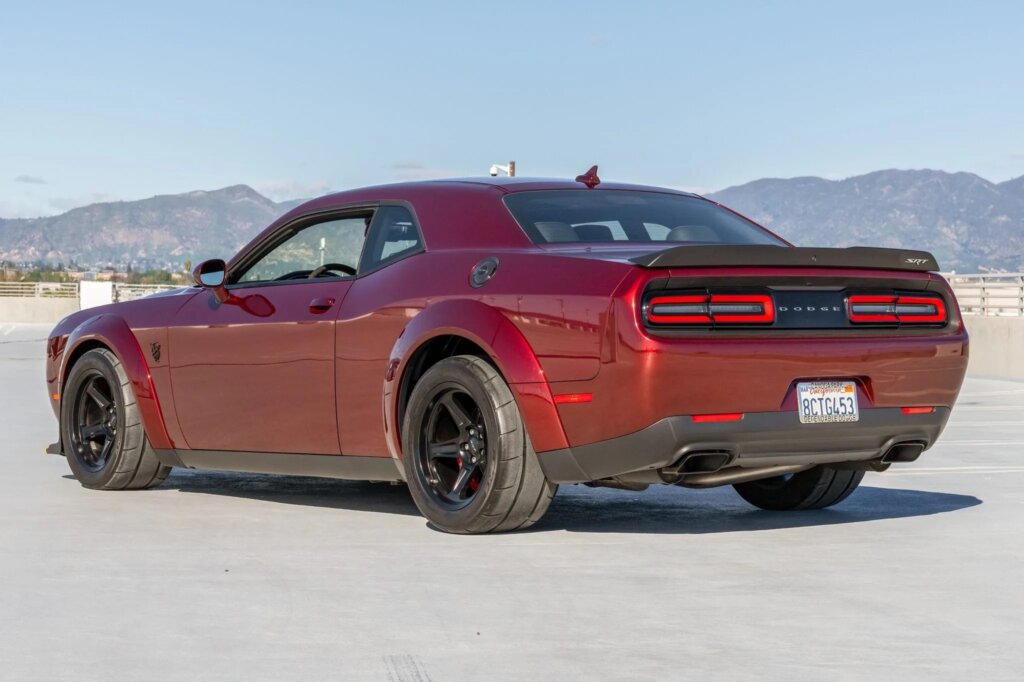 Red Dodge Demon parked on the top of a parking garage with sky in background