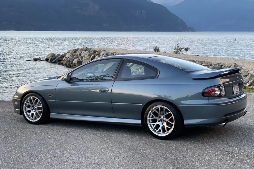 Blue grey GTO parked infant of a lake