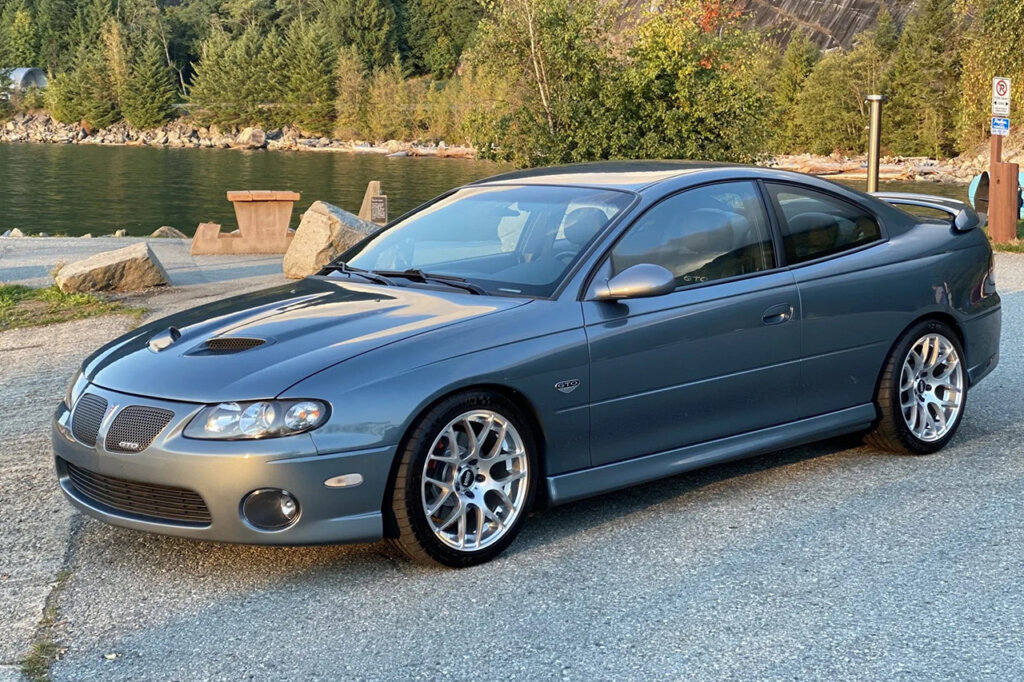 Blue GTO from 2004 parked next to a lake