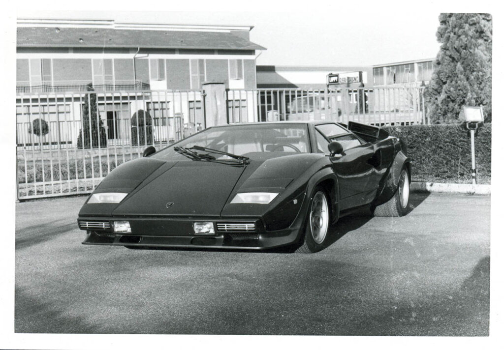 lamborghini countach next to a house