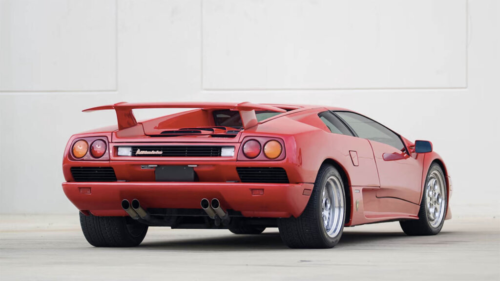 red lamborghini diablo next to a building