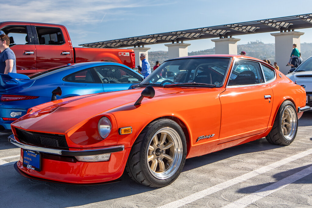 Watanabe Wheels on an orange Fairlady Z parked next to other cars