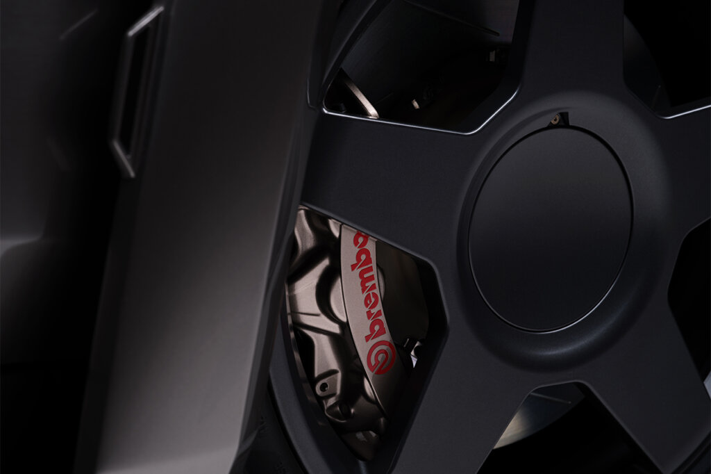 Brembo brake calipers behind the spokes of a black wheel