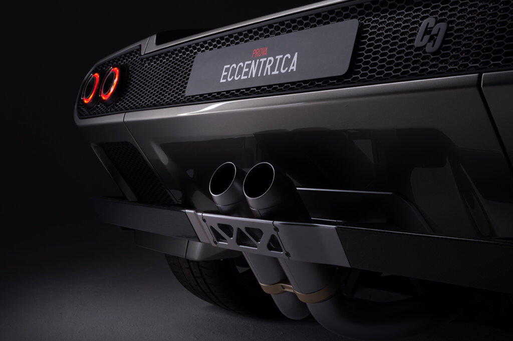 Rear side of the Diablo that has a name where the license plate goes. It says Eccentrica really dark background behind the car