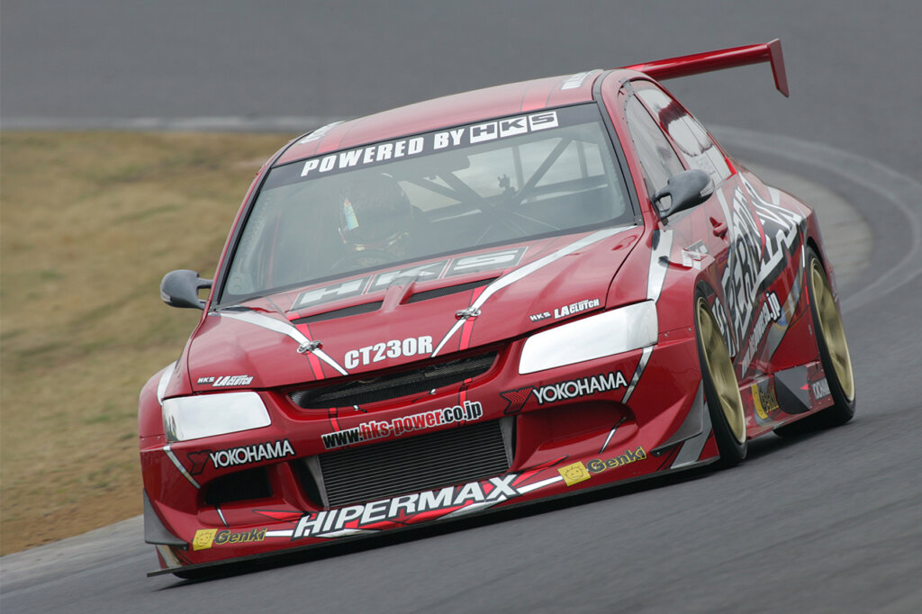 Red CT230R HKS EVO driving fast on a racetrack