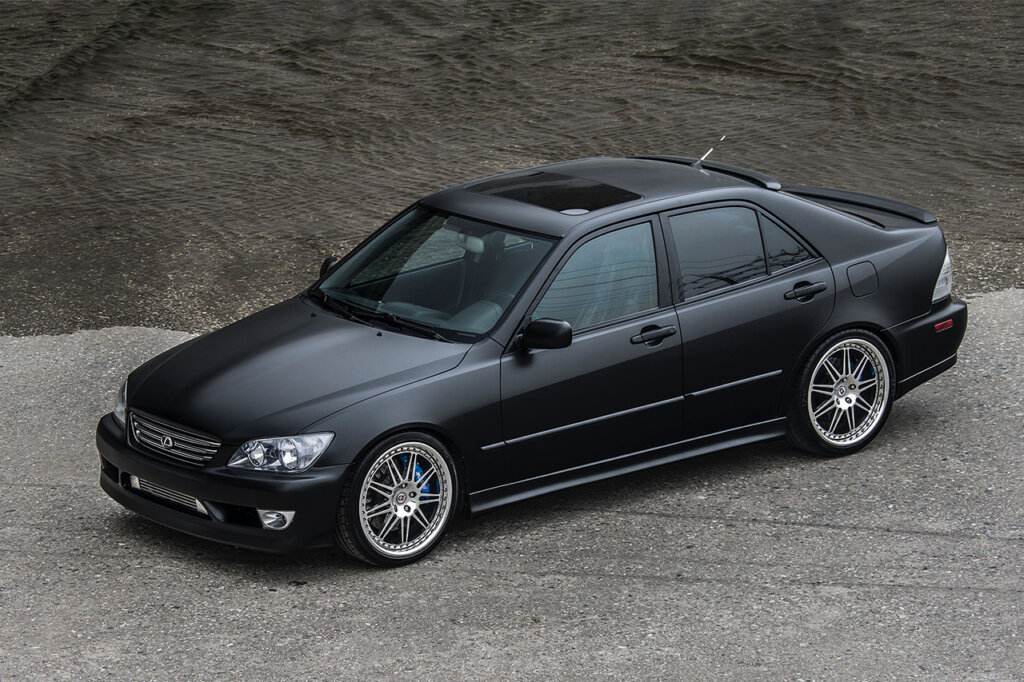 black 4 door car next to water and on a concrete floor