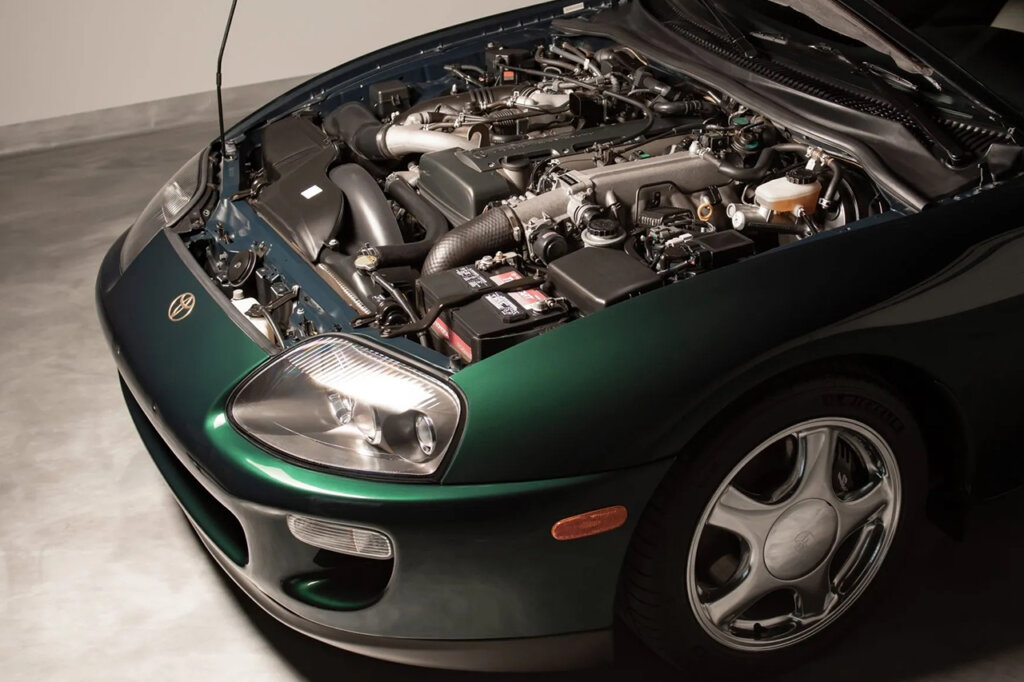 Green MK4 Supra hood open showing a 2JZ engine