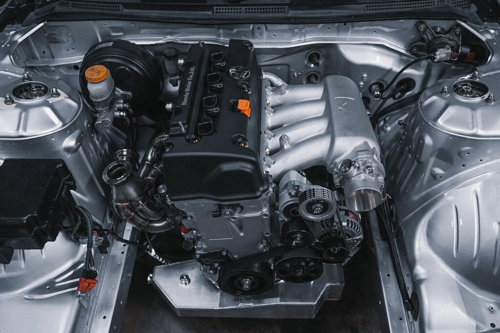 engine with black valve cover in a silver Nissan s15 chassis