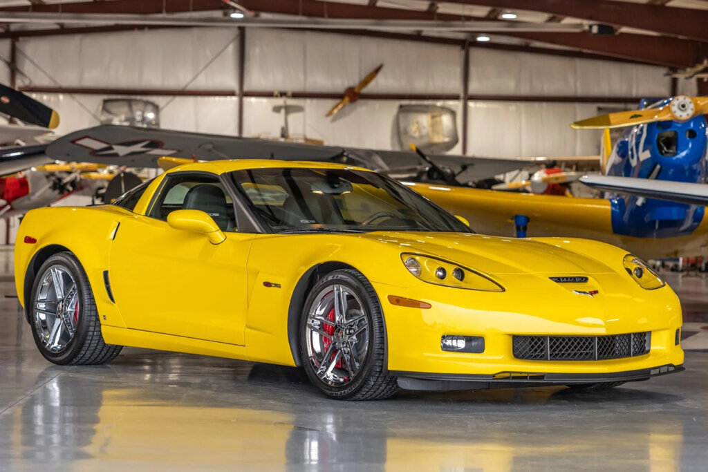 Yellow c6 corvette parked in an airplane warehouse