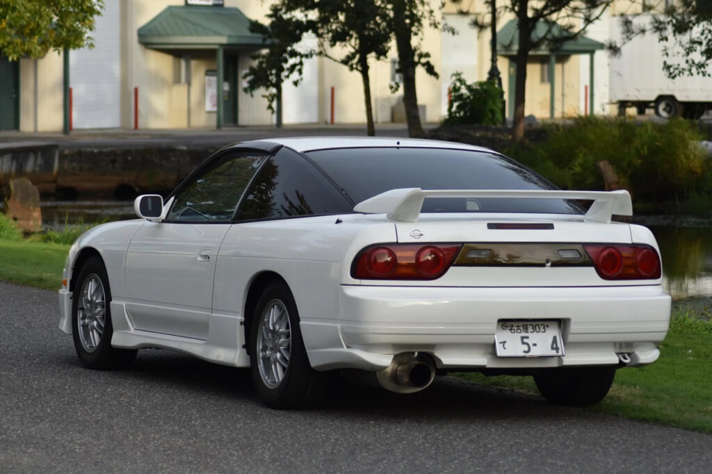 rear side of the 180sx with palm trees and a sunset in the back