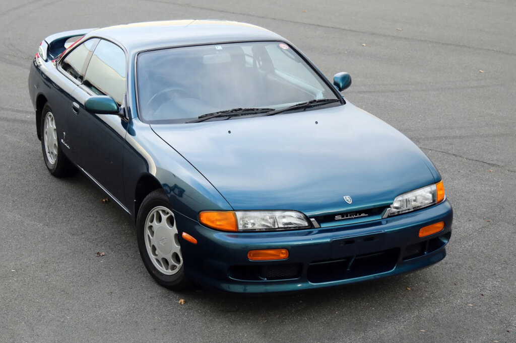 stock green Nissan s14 on asphalt