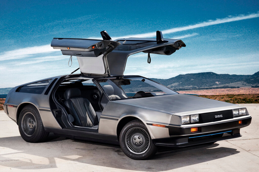 DMC Delorean with gull wing doors open and blue sky with white streak in the back
