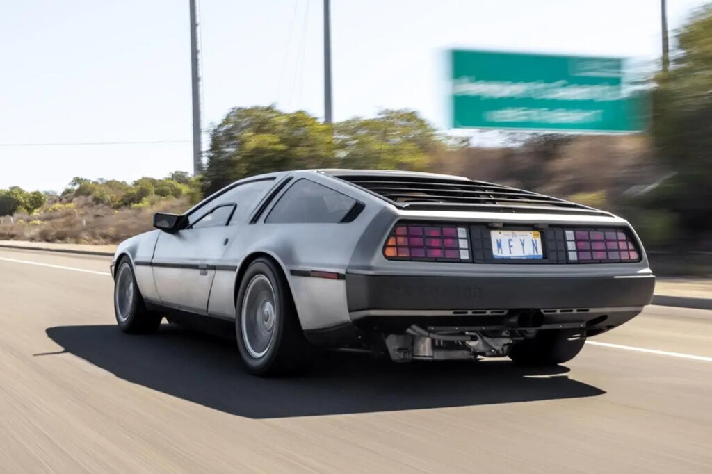 DMC Delorean driving fast on the freeway