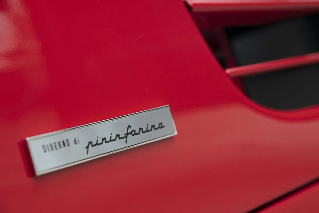 Red Ferrari 512M with a silver badge that says Designo Di Pinifarina