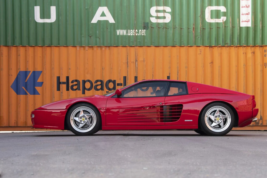 Side profile of a red 512M in front a yellow container that says Hapao in blue and a green container with UASC in white