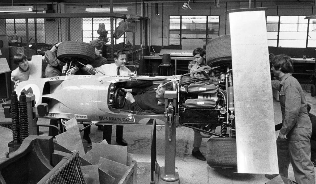 bruce mclaren inspecting a mclaren car