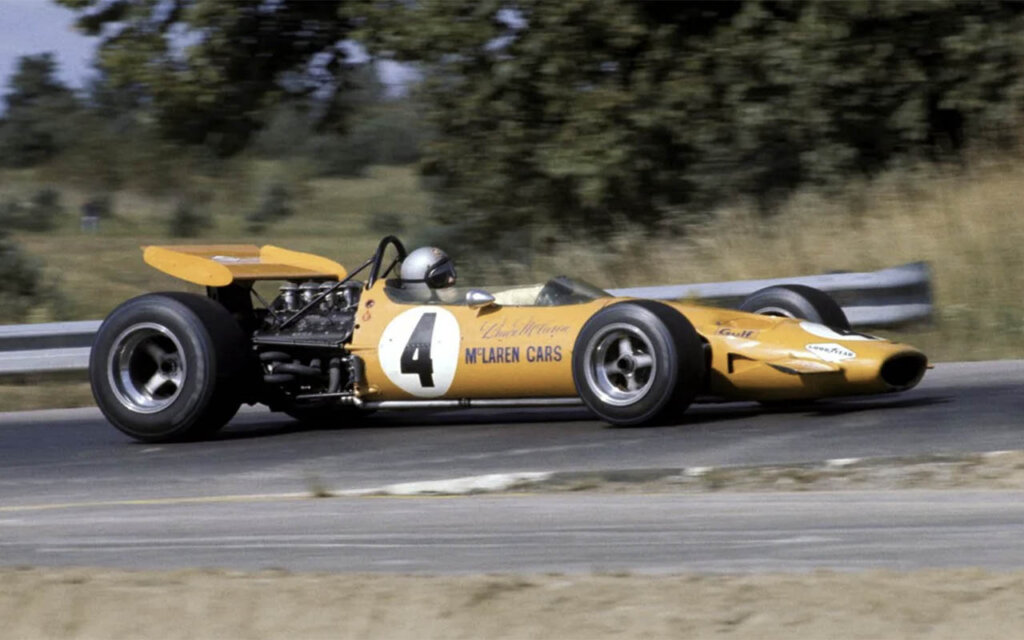 bruce mclaren in a yellow McLaren M7C