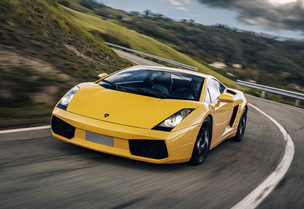 yellow lambo gallrado driving next to a cliff