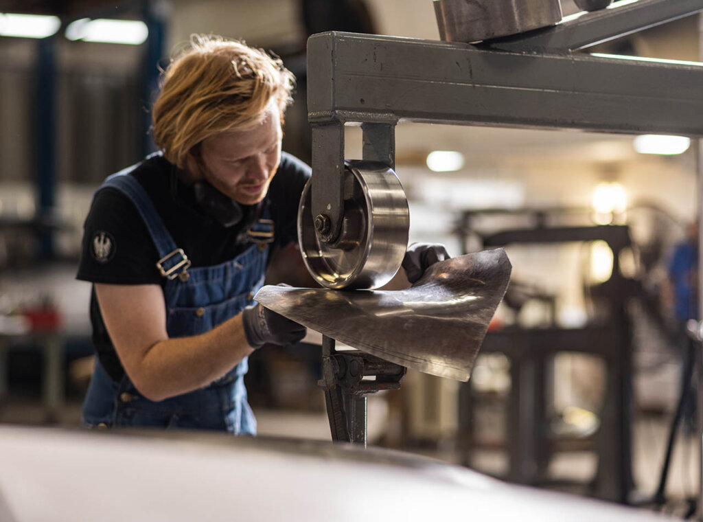 emory motorsports worker flattening metal