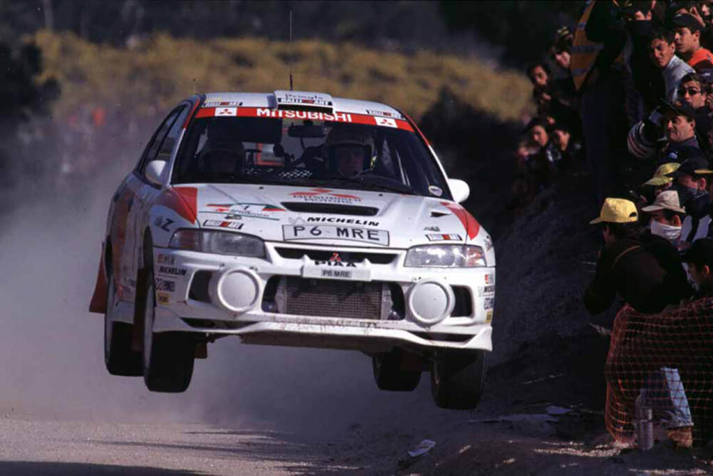 white mitsubishi lancer evo jumping in air