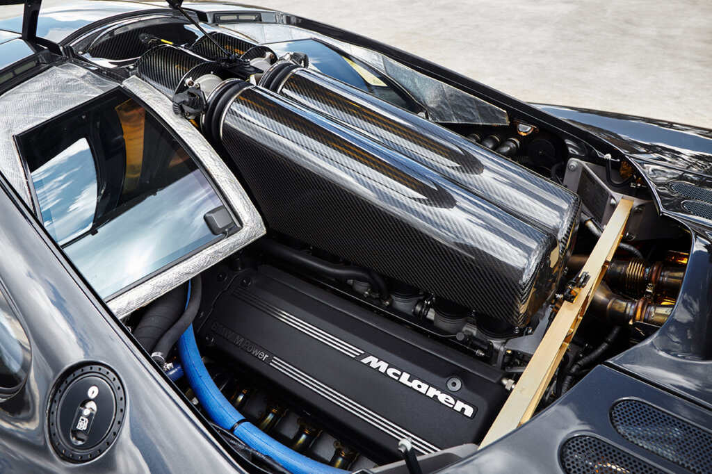 McLaren F1 v12 BMW engine with carbon fiber engine covering and gold strut bar behind it