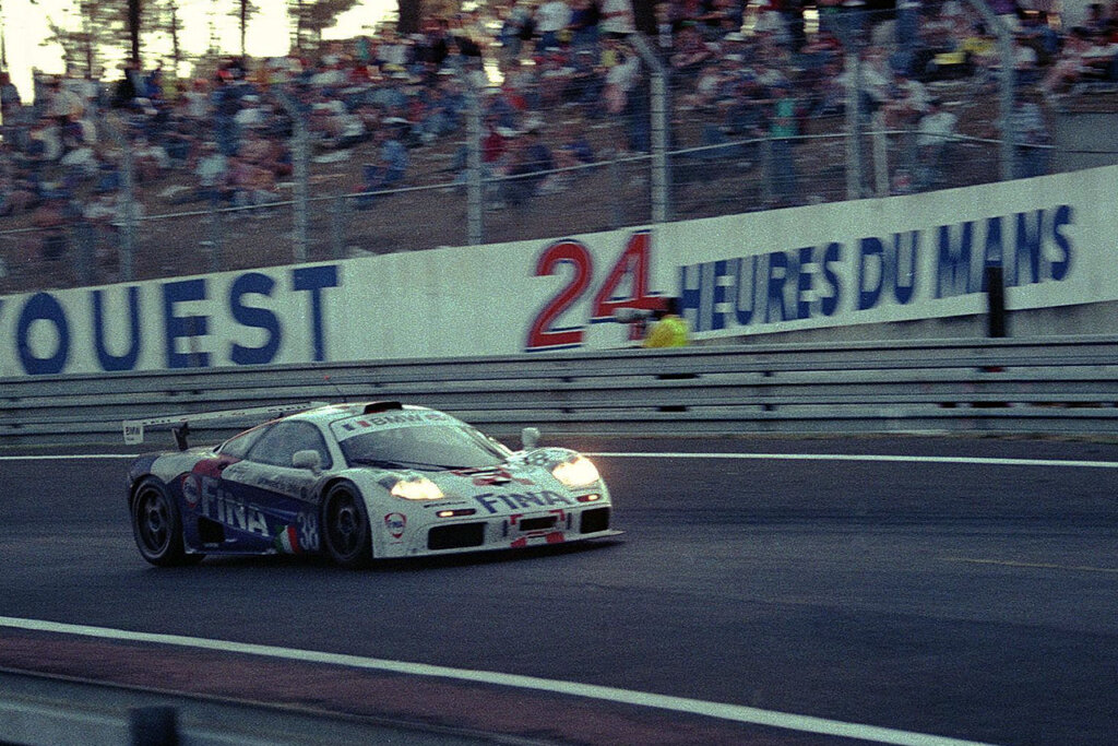 White McLaren on a racetrack with headlights on during the 1996 24hrs Le Mans