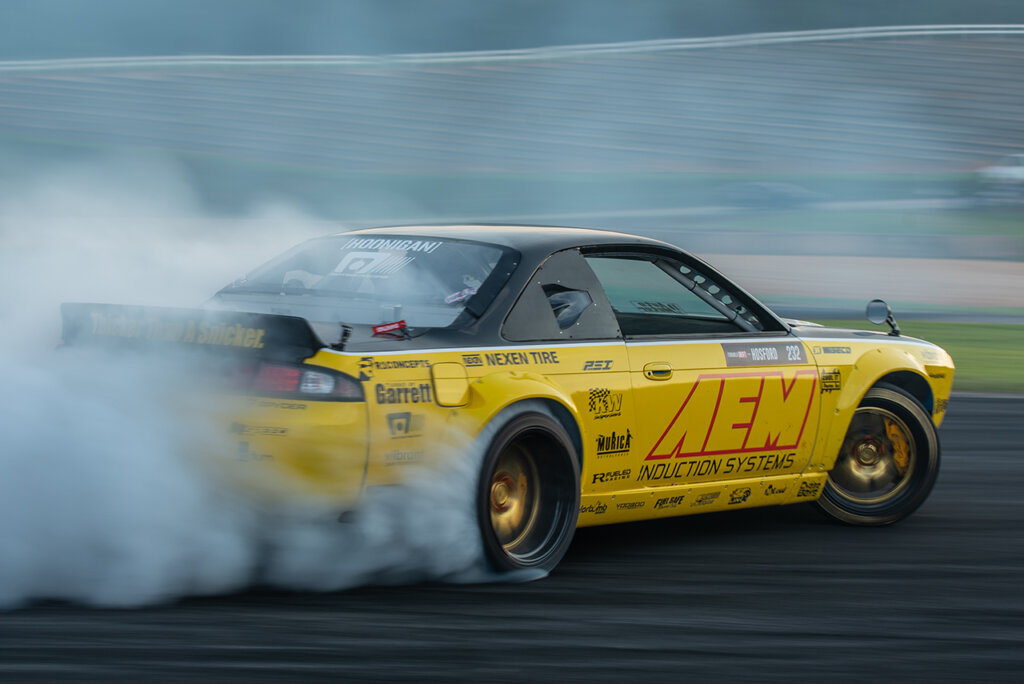 Yellow and Black AEM livery on s14 drifting with a smoke trail