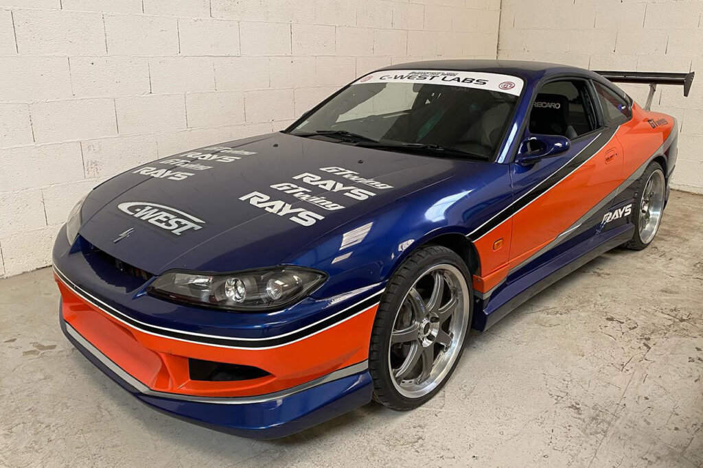 Blue and orange race livery Fast and Furious Tokyo Drift Tribute Nissan Silvia S15 parked in a garage