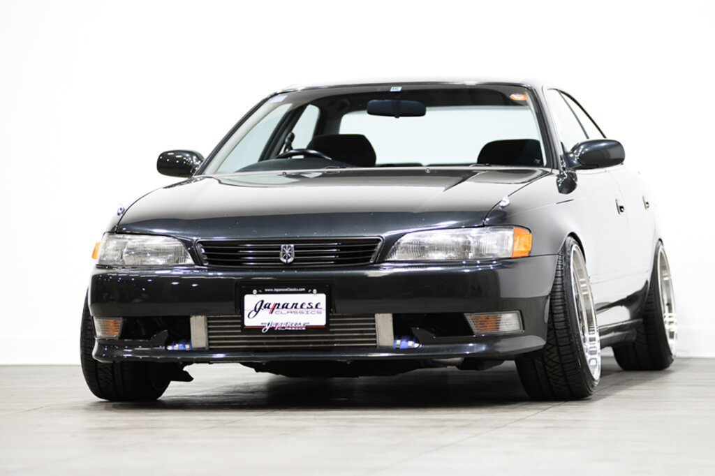 black Toyota Mark 2 parked in a showroom floor